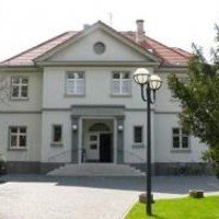 Das weiße, zweistöckige Gebäude des Gemeindezentrums mit Giebeldach.